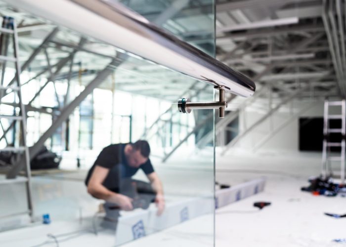 man-working-glass-wall-with-blue-sign-that-says-word-glass-it